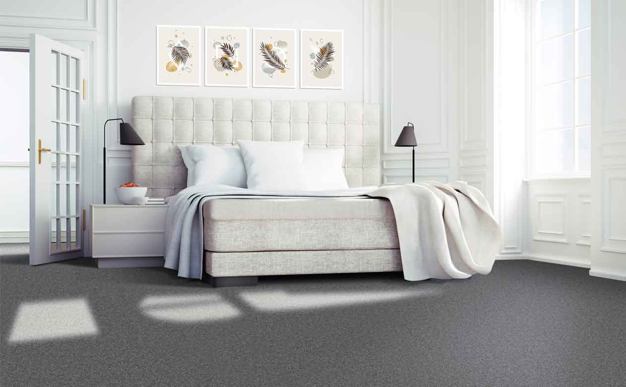 dark grey carpet in bedroom with cream tone bedframe and light grey bedsheets